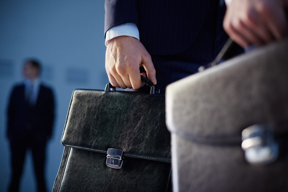 Close-up of a briefcase held by a person in a business suit